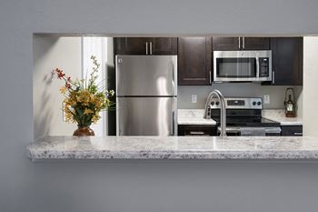 Kitchen with Peek Through with Granite Countertops and Stainless Steel Appliances